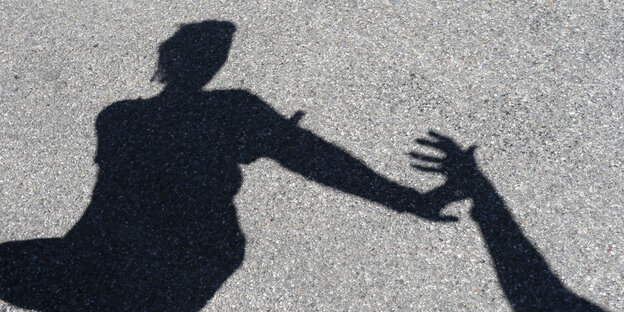 der Schatten einer Person, die eine Hand abwehrt der Schatten einer Person, die eine Hand abwehrt