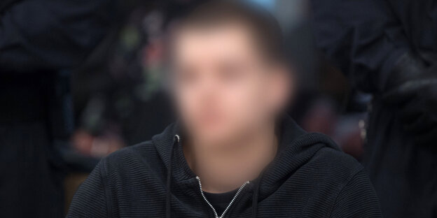 Ein Mann wird von Polizisten zu Prozessbeginn in den Verhandlungssaal geführt Ein Mann wird von Polizisten zu Prozessbeginn in den Verhandlungssaal geführt