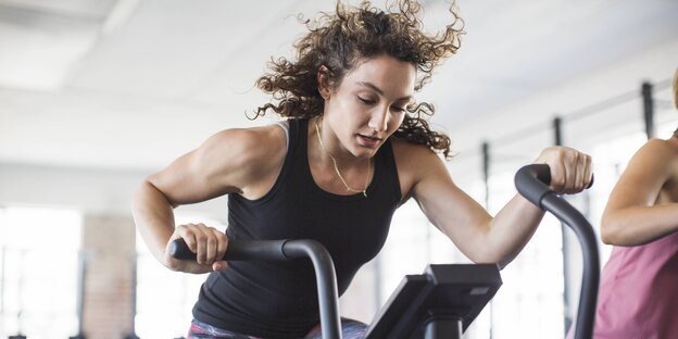 Eine Frau auf einem Laufgerät im Fitnessstudio Eine Frau auf einem Laufgerät im Fitnessstudio