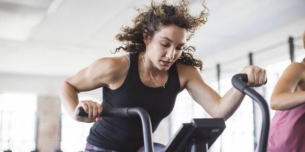 Eine Frau auf einem Laufgerät im Fitnessstudio