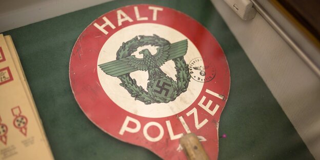 Eine Haltekelle, auf der ein Adler mit Hakenkreuz abgebildet ist, oben und unten steht "Halt Polizei" Eine Haltekelle, auf der ein Adler mit Hakenkreuz abgebildet ist, oben und unten steht "Halt Polizei"