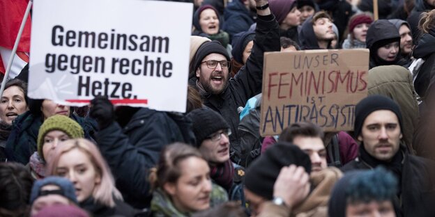 Demonstranten und Demonstrantinnen halten Schilder in die Höhe, auf denen "Gemeinsam gegen rechte Hetze" und "Unser Feminismus ist antirassistisch" steht Demonstranten und Demonstrantinnen halten Schilder in die Höhe, auf denen "Gemeinsam gegen rechte Hetze" und "Unser Feminismus ist antirassistisch" steht