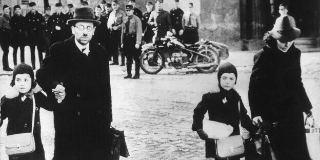 Eine jüdische Familie flüchtet unter den höhnischen Blicken von Nazis im Juni 1939 aus dem Memelland mit Ziel Litauen. Eine jüdische Familie flüchtet unter den höhnischen Blicken von Nazis im Juni 1939 aus dem Memelland mit Ziel Litauen.