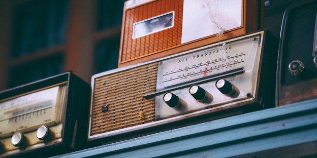 alte Radios auf einem blauen Regalbrett alte Radios auf einem blauen Regalbrett