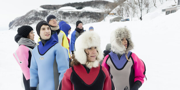 Leute in Thermoanzügen in Eis und Schnee