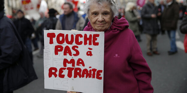Eine ältere Frau trägt bei einer Demo in Paris ein Schild mit der Aufschrift "Hände weg von meiner Rente" Eine ältere Frau trägt bei einer Demo in Paris ein Schild mit der Aufschrift "Hände weg von meiner Rente"