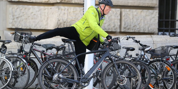 Jürgen Trittin in grüner Jacke steigt auf ein E-Bike Jürgen Trittin in grüner Jacke steigt auf ein E-Bike