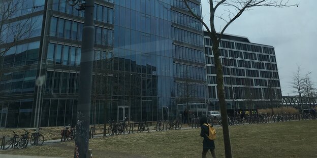 Zwei dunkle, meist verspiegelte Fassaden. Eine davon gehört zu einem Hochhaus. Zwei dunkle, meist verspiegelte Fassaden. Eine davon gehört zu einem Hochhaus.