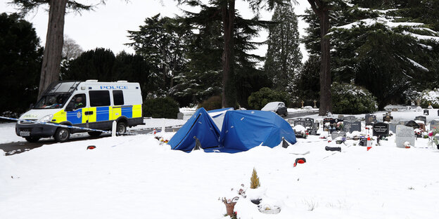 Ein Polizeiwagen neben einem verschneiten Friedhof Ein Polizeiwagen neben einem verschneiten Friedhof