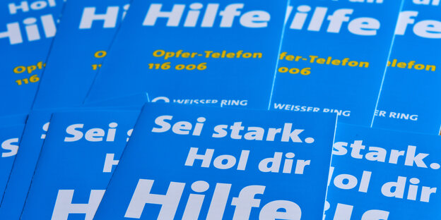 Mehrere blaue Broschüren des Weißen Rings liegen übereinander. Auf den Broschüren steht: "Sei stark, hol dir Hilfe". Mehrere blaue Broschüren des Weißen Rings liegen übereinander. Auf den Broschüren steht: "Sei stark, hol dir Hilfe".