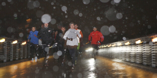 SportlerInnen laufen durch den Schneeregen SportlerInnen laufen durch den Schneeregen