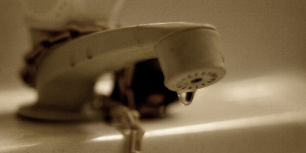 Ein alter Wasserhahn, aus dem ein Tropfen Wasser hervorschaut Ein alter Wasserhahn, aus dem ein Tropfen Wasser hervorschaut