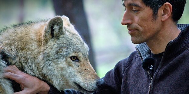 Ein Mann neben einem Wolf Ein Mann neben einem Wolf
