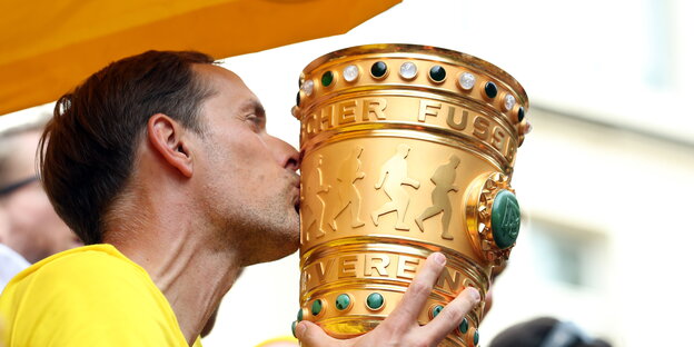 ein Mann küsst einen großen Pokal ein Mann küsst einen großen Pokal