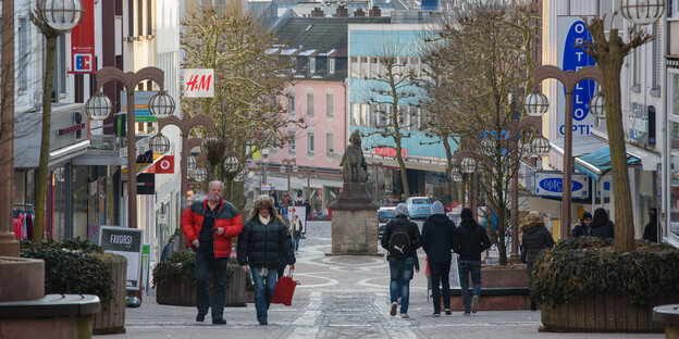 Passanten in der Fußgängerzone, daneben Geschäfte Passanten in der Fußgängerzone, daneben Geschäfte