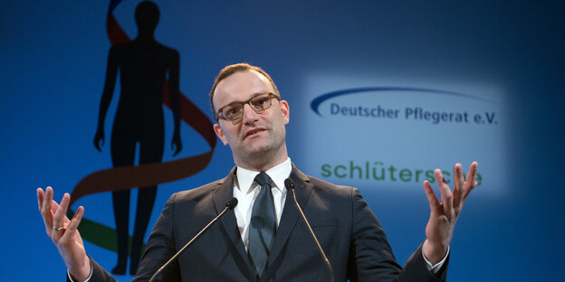 Jens Spahn steht selbstgefällig da und hebt abwiegelnd beide Hände Jens Spahn steht selbstgefällig da und hebt abwiegelnd beide Hände