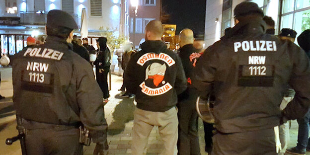 Polizisten vor einer Gruppe Personen, die "Osmanen Germania"-Pullover tragen Polizisten vor einer Gruppe Personen, die "Osmanen Germania"-Pullover tragen