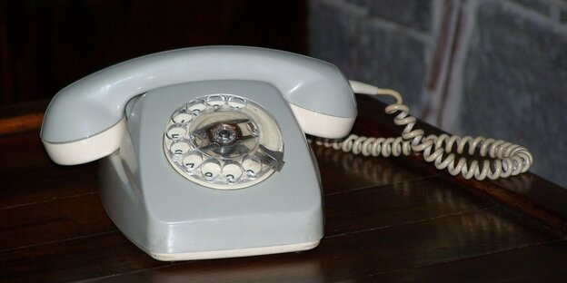 Ein altes Telefon mit Wählscheibe und geringeltem Kabel. Ein altes Telefon mit Wählscheibe und geringeltem Kabel.