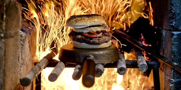 Ein Burger vor loderndem Feuer