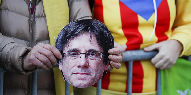 Protestler halten den auf Pappe gedruckten Kopf von Carles Puigdemont Protestler halten den auf Pappe gedruckten Kopf von Carles Puigdemont