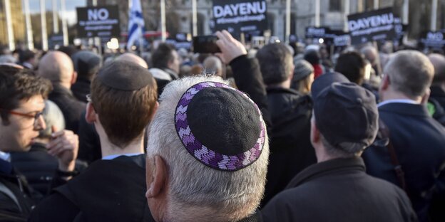 Viele Menschen demonstrieren mit Schildern auf einem Platz, einige Demonstranten tragen Kippa Viele Menschen demonstrieren mit Schildern auf einem Platz, einige Demonstranten tragen Kippa