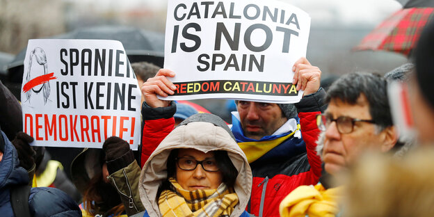 Eine Gruppe demonstriert mit Plakaten, auf einem steht auf englisch: Katalonien ist nicht Spanien Eine Gruppe demonstriert mit Plakaten, auf einem steht auf englisch: Katalonien ist nicht Spanien