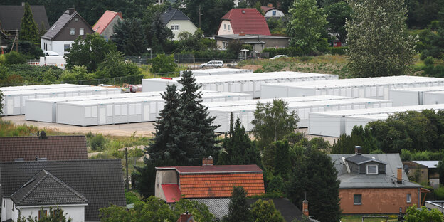 Ein Containerdorf zwischen Föhren und Einfamilienhäusern Ein Containerdorf zwischen Föhren und Einfamilienhäusern