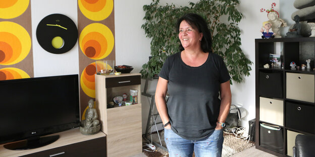 eine Frau steht in einem Wohnzimmer eine Frau steht in einem Wohnzimmer