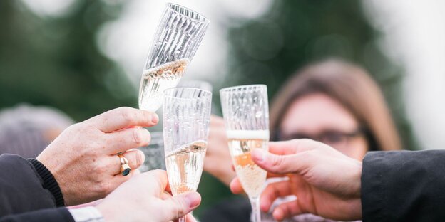 Menschen stoßen mit Champagnergläsern an Menschen stoßen mit Champagnergläsern an