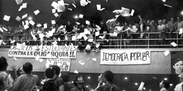 Menschen stehen auf einer Brütung, Papierblätter fliegen umher Menschen stehen auf einer Brütung, Papierblätter fliegen umher
