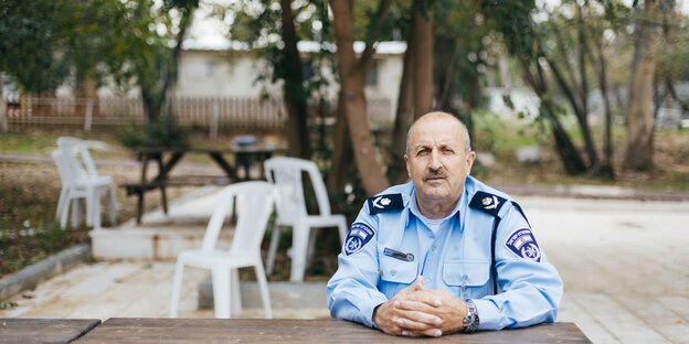 Ein Polizist sitzt unter Bäumen Ein Polizist sitzt unter Bäumen