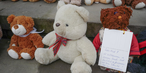 Drei Teddybären, vor einem lehnt eine Karte mit dem handgeschriebenen Wortlaut «Liebe Kind! sei willkommen in unserem Land und herzlichst aufgenommen mit deiner Familie!». Drei Teddybären, vor einem lehnt eine Karte mit dem handgeschriebenen Wortlaut «Liebe Kind! sei willkommen in unserem Land und herzlichst aufgenommen mit deiner Familie!».