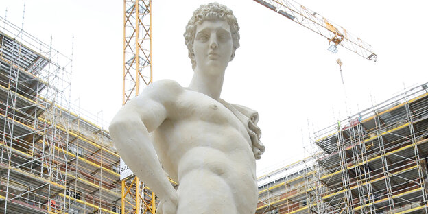 Eine Statue im Hof des Humboldt Forums im Berliner Schloss, im Hintergrund ein Kran Eine Statue im Hof des Humboldt Forums im Berliner Schloss, im Hintergrund ein Kran