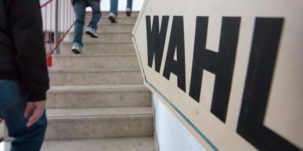Männer gehen vor Wahl-Schild Treppe hoch Männer gehen vor Wahl-Schild Treppe hoch
