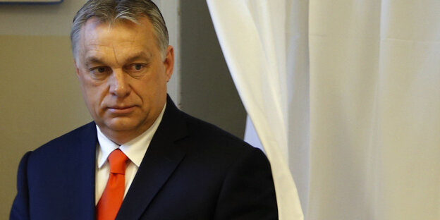 Viktor Orban kommt neben einem Vorhang hervor Viktor Orban kommt neben einem Vorhang hervor