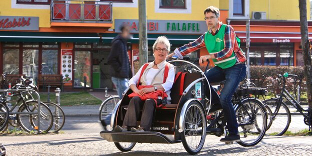 Veit Hannemann fährt eine Rikscha, in deren Sitz eine Frau sitzt Veit Hannemann fährt eine Rikscha, in deren Sitz eine Frau sitzt