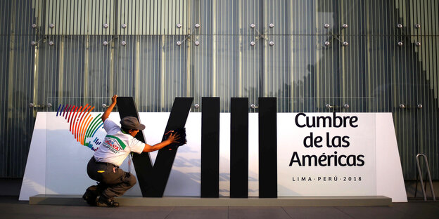 Eine Frau putzt ein Banner im Vorfeld des Amerika-Gipfels in Peru Eine Frau putzt ein Banner im Vorfeld des Amerika-Gipfels in Peru