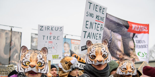 Demonstranten mit Tigermasken tragen Schilder und Transparente. Demonstranten mit Tigermasken tragen Schilder und Transparente.