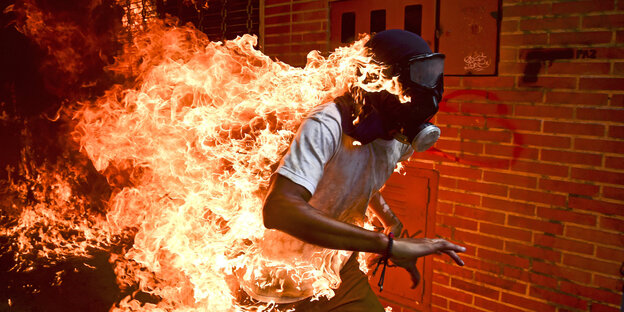 Ein Mann in Flammen rennt Ein Mann in Flammen rennt