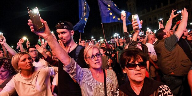 Menschen halten Handys und Europafahnen in die Luft Menschen halten Handys und Europafahnen in die Luft