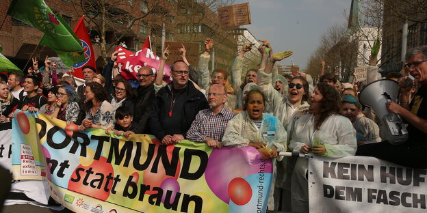 Menschen in Dortmund tragen ein buntes Banner auf dem "Dortmund, bunt statt braun" steht Menschen in Dortmund tragen ein buntes Banner auf dem "Dortmund, bunt statt braun" steht