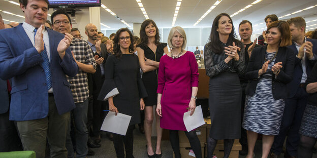 16.04.2018, USA, New York: Jodi Kantor (3.v.l) und Megan Twohey (4.v.l), Journalistinen der New York Times, stehen nach der Bekanntgabe der Gewinner der Pulitzer-Preise im Newsroom der Zeitung. 16.04.2018, USA, New York: Jodi Kantor (3.v.l) und Megan Twohey (4.v.l), Journalistinen der New York Times, stehen nach der Bekanntgabe der Gewinner der Pulitzer-Preise im Newsroom der Zeitung.