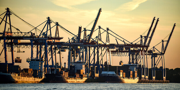 Drei Containerschiffe werden im Hafen abgefertigt, Sonnenuntergang. Drei Containerschiffe werden im Hafen abgefertigt, Sonnenuntergang.