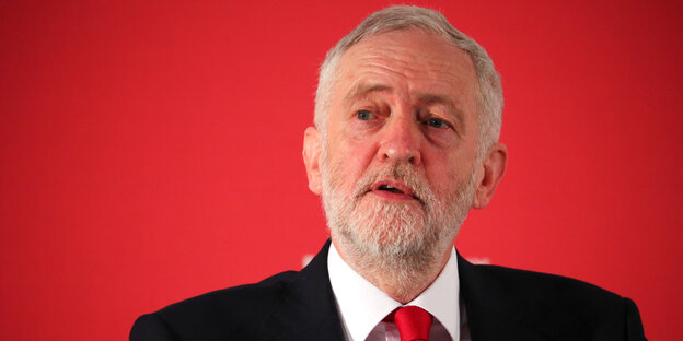 Jeremy Corbyn vor rotem Hintergrund Jeremy Corbyn vor rotem Hintergrund