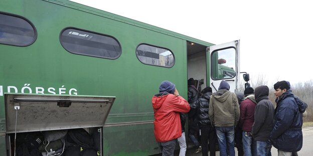 Geflüchtete steigen in einen Bus der ungarischen Polizei ein Geflüchtete steigen in einen Bus der ungarischen Polizei ein
