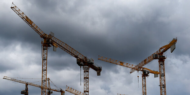 Mehrere Kräne vor grauen Wolken Mehrere Kräne vor grauen Wolken