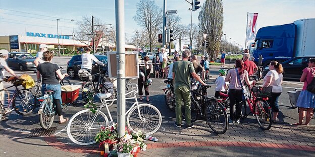 An einer Straßenkreuzung stehen Fahrradfahrer und blicken sich über die Straße hinweg an.