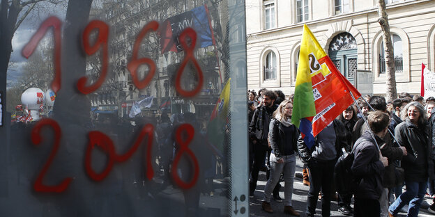 Menschen demonstrieren; daneben stehen auf eine Scheibe geschrieben zwei Jahreszahlen: 1968 und 2018 Menschen demonstrieren; daneben stehen auf eine Scheibe geschrieben zwei Jahreszahlen: 1968 und 2018