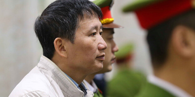 Trinh Xuan Thanh steht neben Polizisten Trinh Xuan Thanh steht neben Polizisten