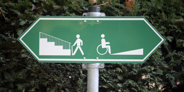 Ein Schild, links ist jemand vor einer Treppe, rechts ist jemand vor einer Rollstuhlrampe abgebildet, Treppe und Rampe führen in unterschiedliche Richtungen Ein Schild, links ist jemand vor einer Treppe, rechts ist jemand vor einer Rollstuhlrampe abgebildet, Treppe und Rampe führen in unterschiedliche Richtungen